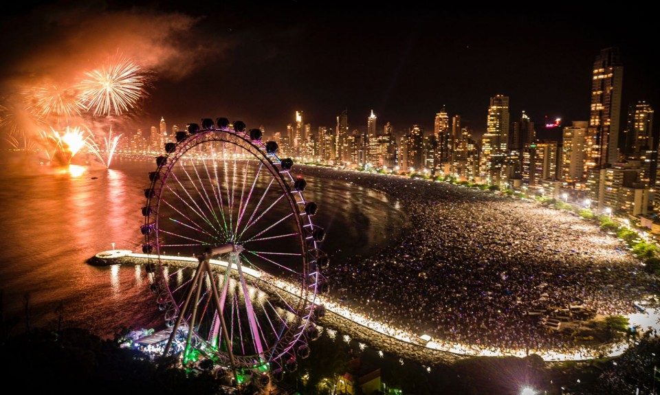 Queima de fogos em Balneário Camboriú, com foco na roda gigante e na praia com muitas pessoas. Fonte: Meio&Evento/Hildo Junior.